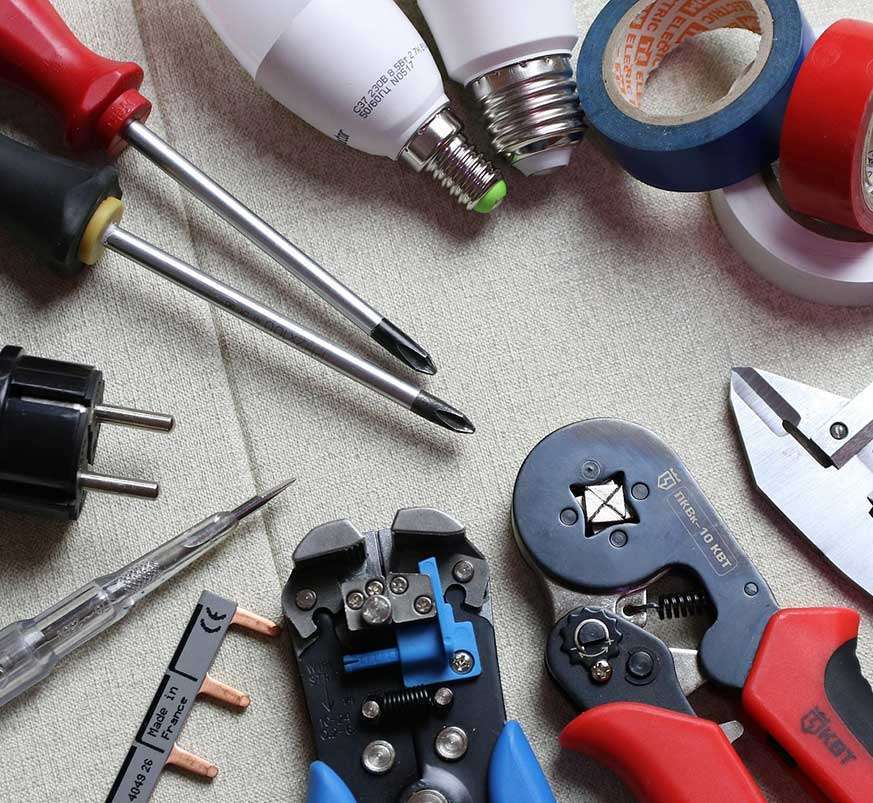 Assorted electrical tools including screwdrivers, wire strippers, light bulbs, electrical tape, and connectors, representing DB Electrical Services' commitment to high-quality installations and repairs.