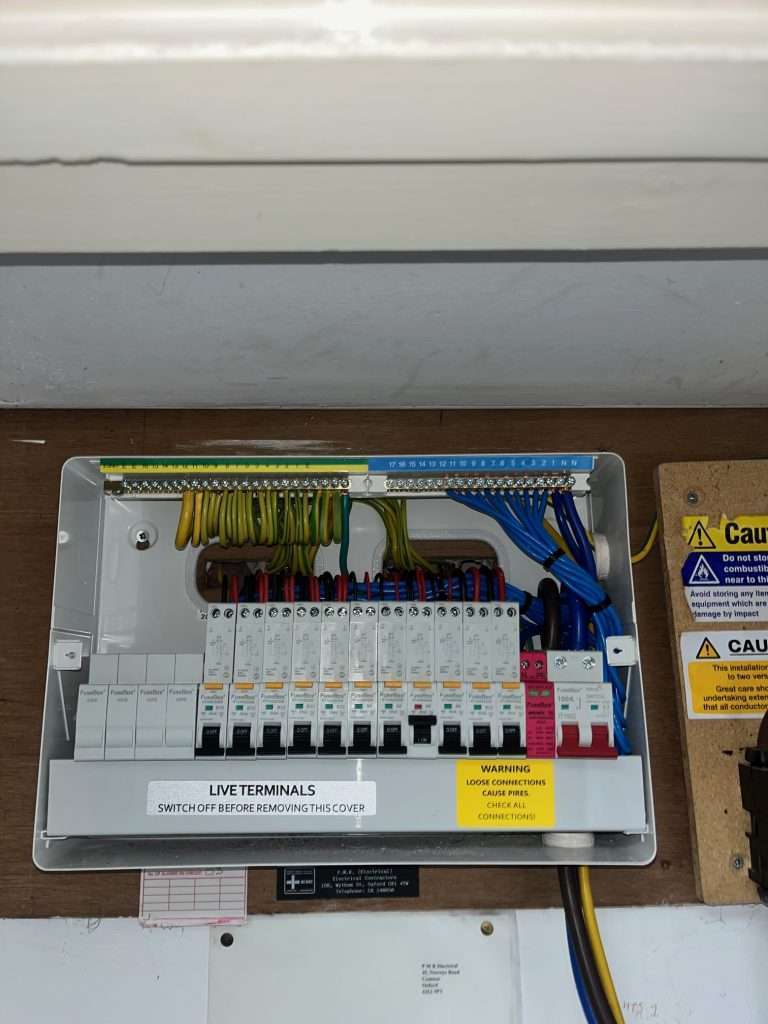 Fuse box with multiple circuit breakers and wiring, showcasing a modern consumer unit upgrade compliant with 18th Edition regulations, relevant for electrical safety in Marlow homes.