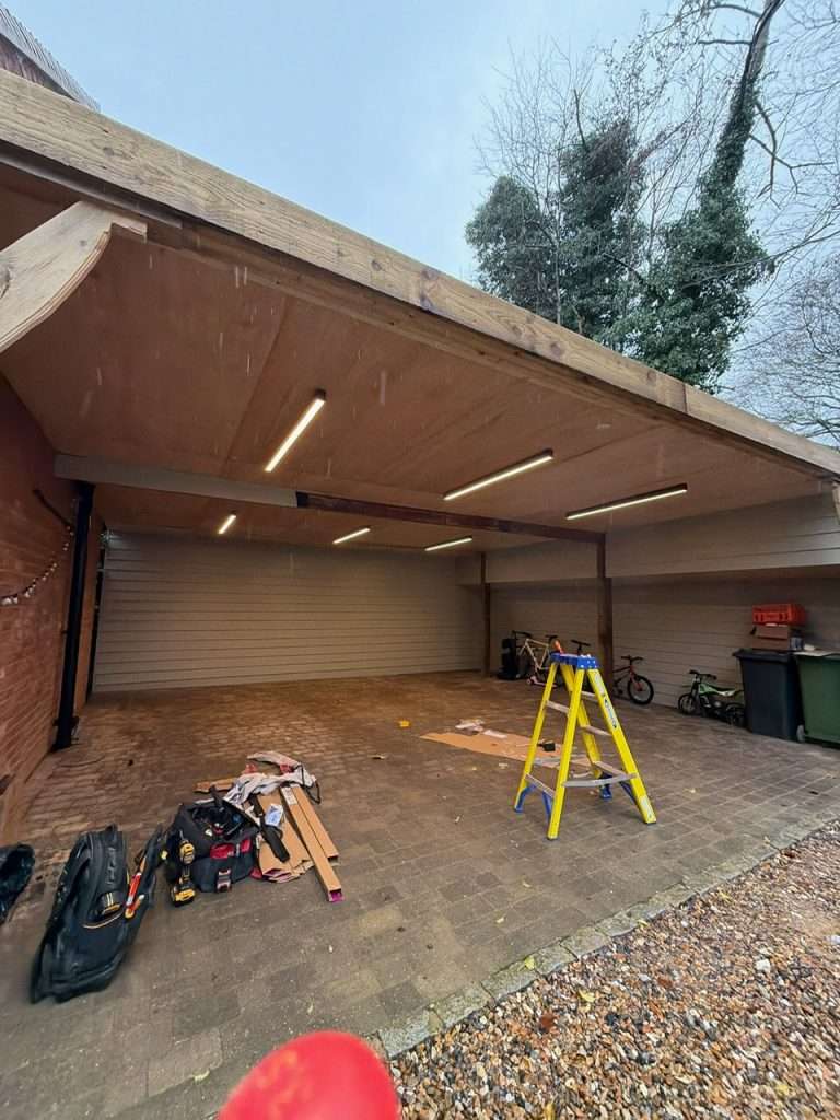 Garage lighting installation with LED lights, tools, and a ladder in a newly constructed garage space in Maidenhead.