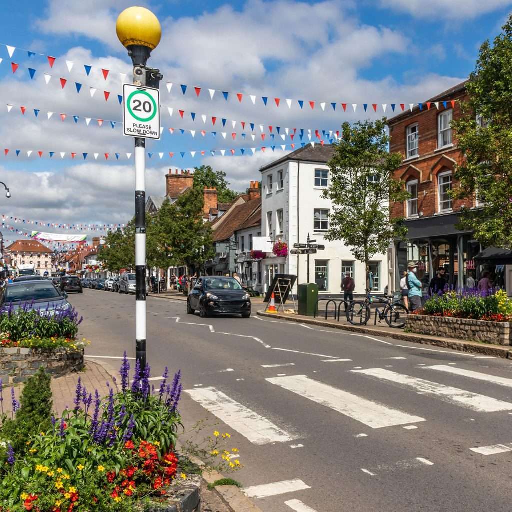 dominic-barao-qualified-electrician-serving-marlow-high-street Marlow High Street scene with 20 mph speed limit sign and festive bunting, showcasing local electrical services.